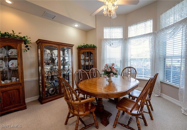 carpeted dining space featuring ceiling fan and plenty of natural light