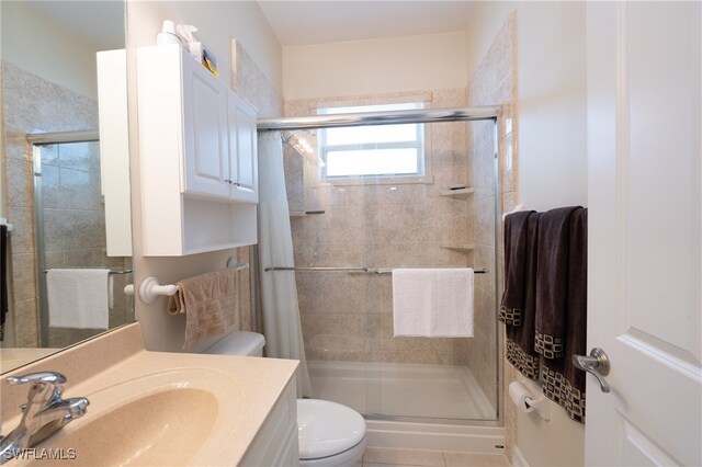 bathroom featuring a shower with curtain, vanity, tile patterned flooring, and toilet