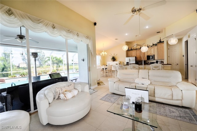 living room featuring ceiling fan with notable chandelier, vaulted ceiling, and light tile patterned floors