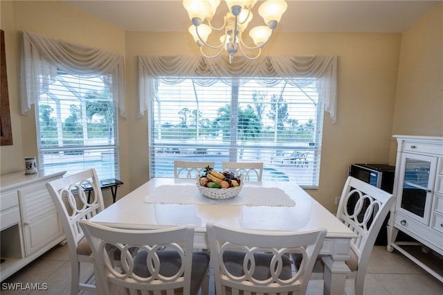 tiled dining area featuring an inviting chandelier