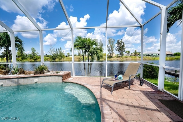 view of pool featuring glass enclosure, a water view, and a patio area