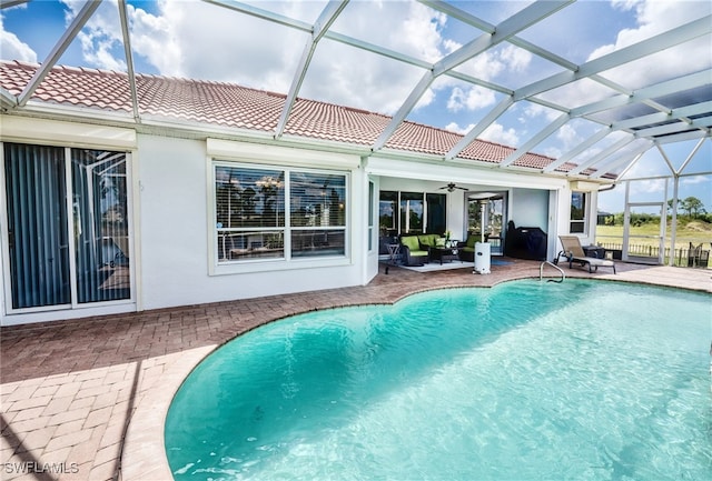 view of swimming pool with a lanai, ceiling fan, and a patio area