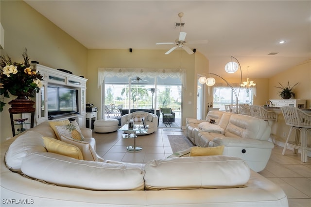 living room with ceiling fan with notable chandelier and light tile patterned floors