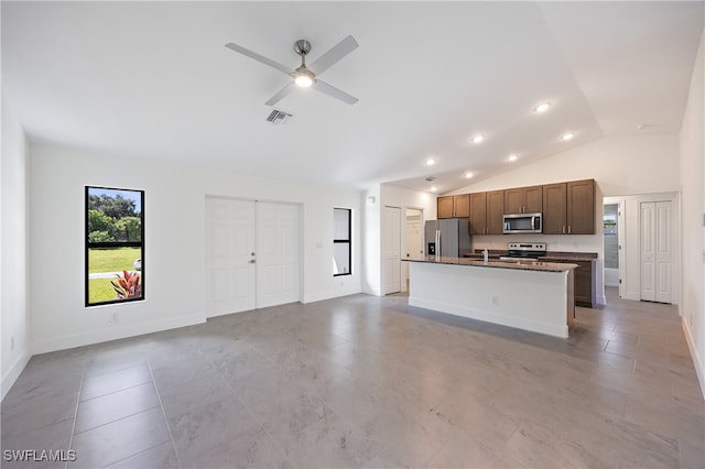 kitchen featuring light tile patterned floors, ceiling fan, a kitchen island with sink, vaulted ceiling, and stainless steel appliances