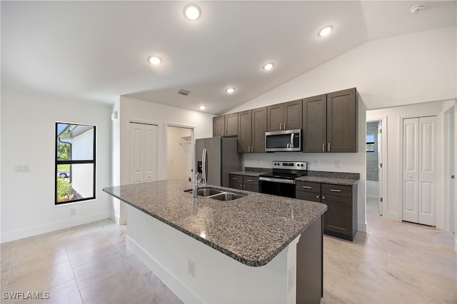 kitchen featuring a center island with sink, lofted ceiling, appliances with stainless steel finishes, and dark brown cabinets