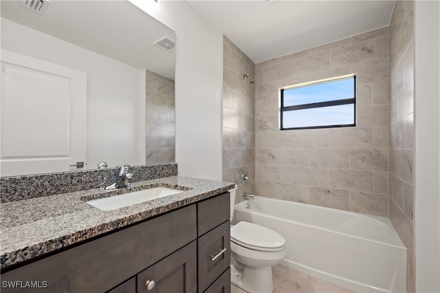 full bathroom featuring tiled shower / bath, vanity, toilet, and tile patterned floors