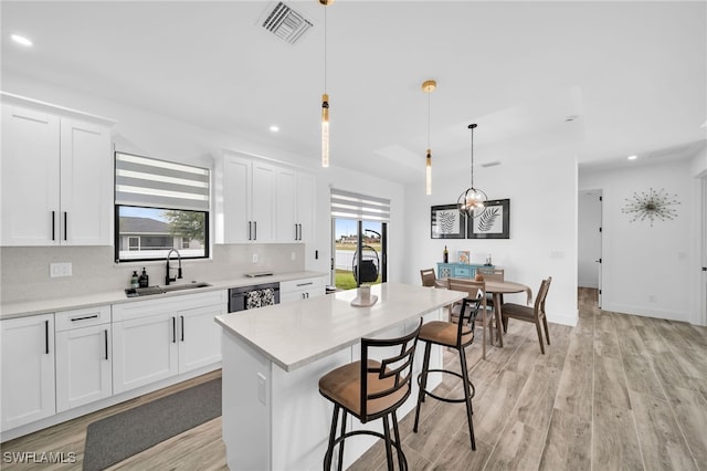 kitchen with white cabinetry, decorative light fixtures, plenty of natural light, and a kitchen island