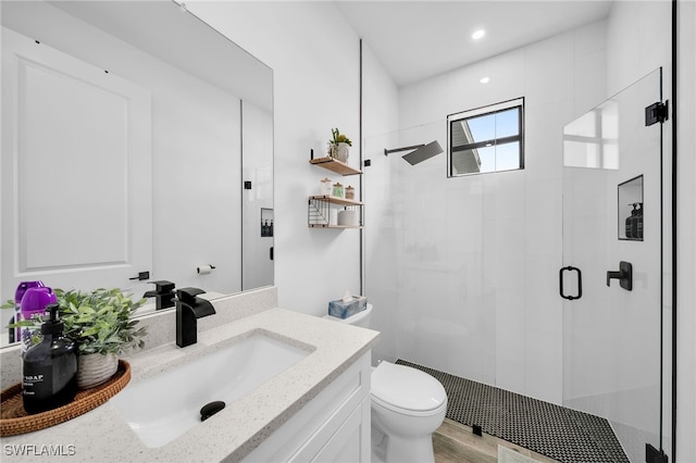 bathroom with vanity, hardwood / wood-style floors, toilet, and walk in shower