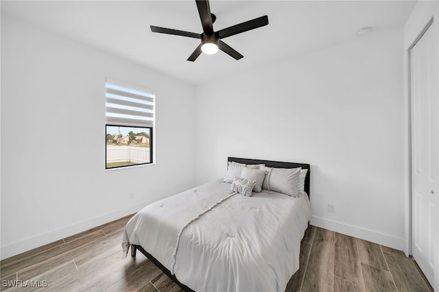 bedroom with a closet, ceiling fan, and wood-type flooring