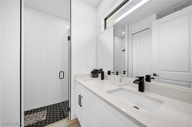 bathroom with vanity, a shower with shower door, and wood-type flooring