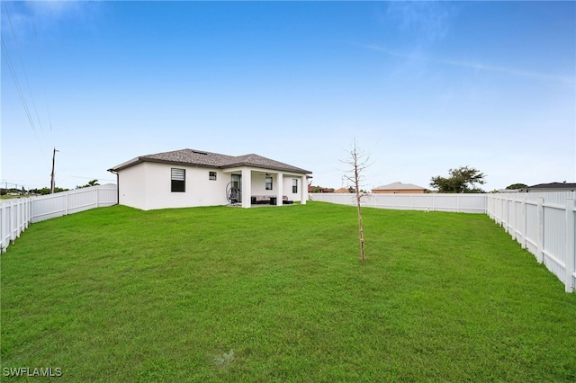 rear view of property featuring a lawn