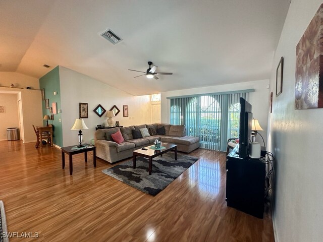 living room with ceiling fan, hardwood / wood-style flooring, and lofted ceiling