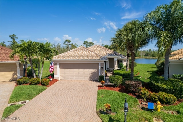 mediterranean / spanish-style home featuring a water view, a front yard, and a garage