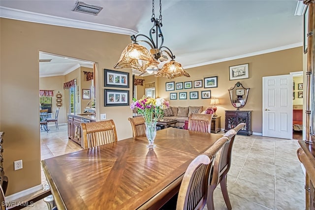 tiled dining room featuring crown molding and an inviting chandelier