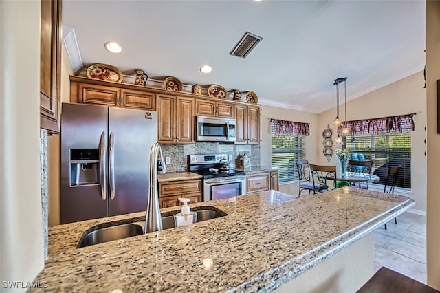 kitchen featuring appliances with stainless steel finishes, sink, hanging light fixtures, lofted ceiling, and ornamental molding