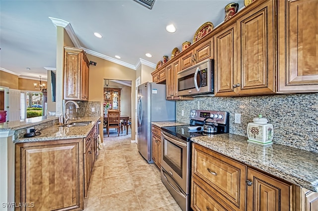 kitchen with sink, kitchen peninsula, stainless steel appliances, ornamental molding, and a chandelier