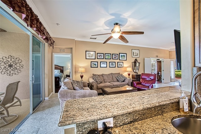 tiled living room with crown molding, sink, and ceiling fan