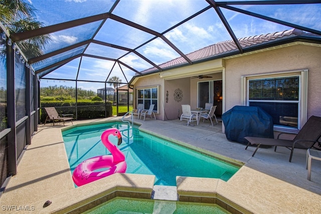 view of swimming pool featuring grilling area, a patio area, glass enclosure, and ceiling fan