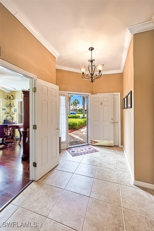 entrance foyer featuring crown molding, ceiling fan with notable chandelier, and light tile patterned floors