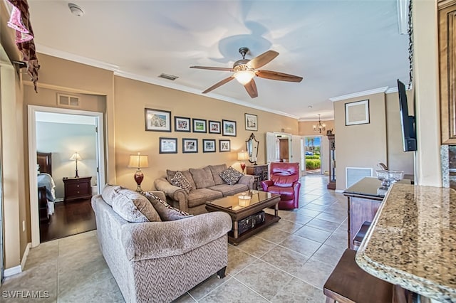 tiled living room featuring crown molding and ceiling fan with notable chandelier