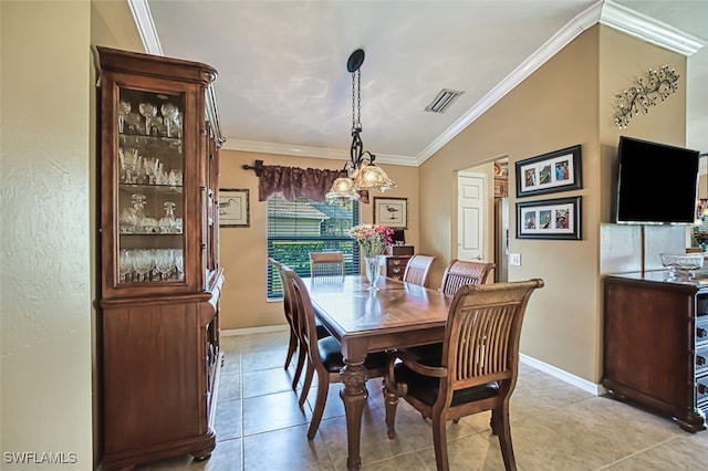 dining area featuring ornamental molding, a chandelier, vaulted ceiling, and light tile patterned flooring