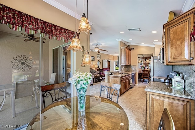 dining area featuring sink, crown molding, light tile patterned flooring, and ceiling fan