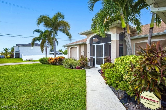 view of front facade featuring a sunroom and a front yard