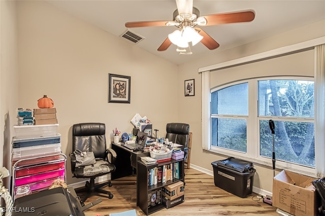 home office with light wood-type flooring and ceiling fan