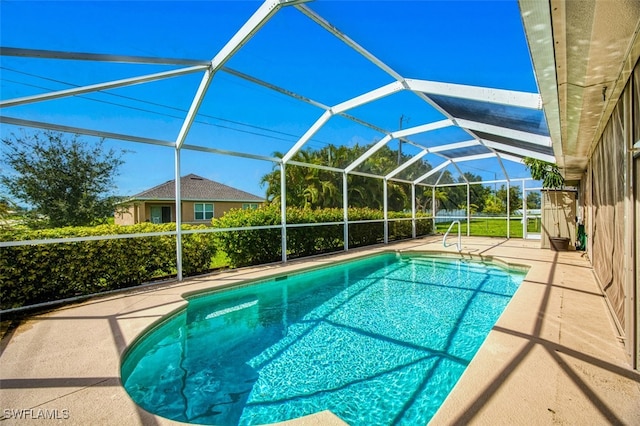 view of swimming pool with glass enclosure and a patio area