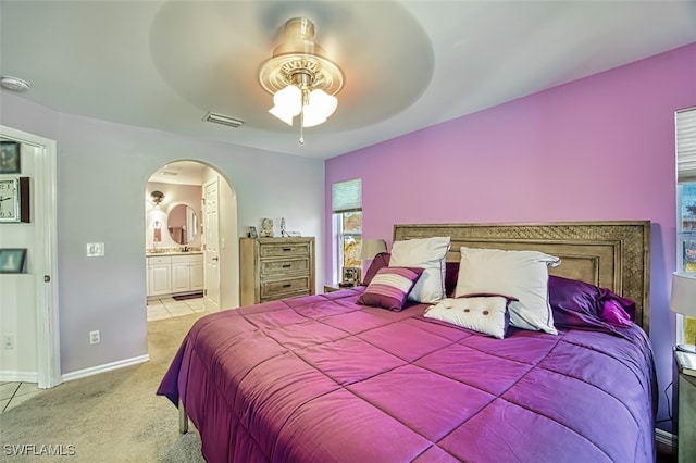 carpeted bedroom with ceiling fan and ensuite bathroom