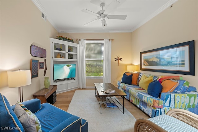 living room featuring ceiling fan, crown molding, and light hardwood / wood-style floors