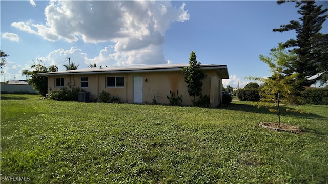 rear view of property with a lawn and central AC