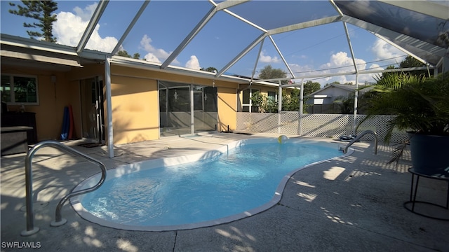 view of pool featuring glass enclosure and a patio area