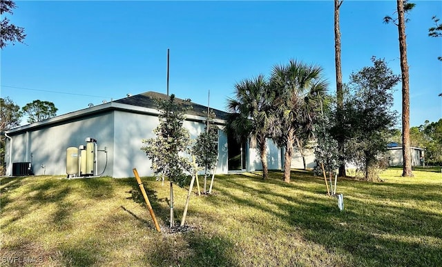 rear view of house featuring a yard and central AC