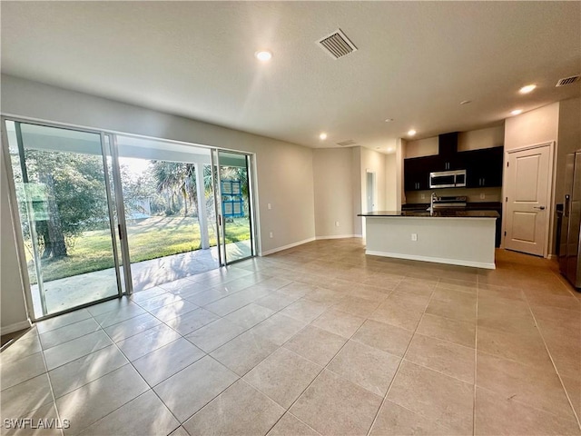 unfurnished living room featuring sink and light tile patterned floors