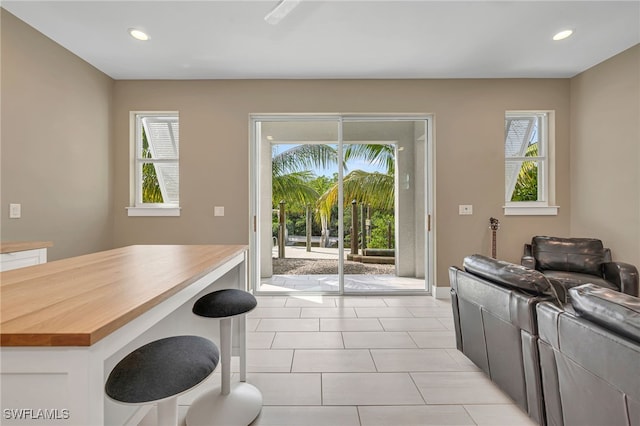 kitchen with wood counters, light tile patterned floors, and a wealth of natural light