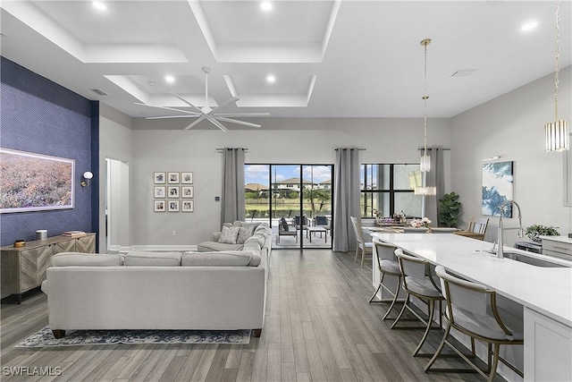 living room with coffered ceiling, sink, ceiling fan, a towering ceiling, and dark hardwood / wood-style flooring