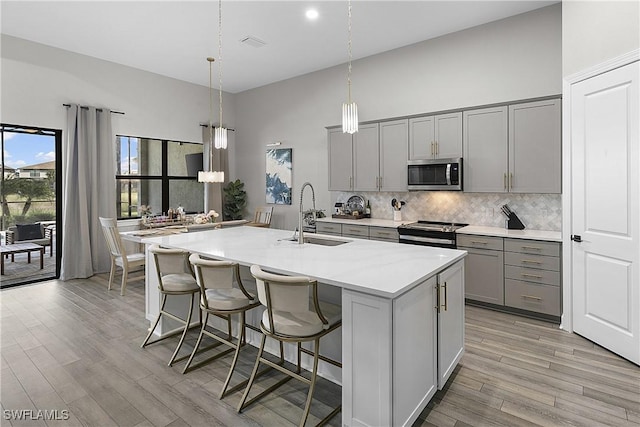 kitchen with appliances with stainless steel finishes, gray cabinetry, and sink