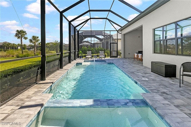 view of pool featuring a patio, glass enclosure, and pool water feature