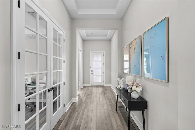 doorway with hardwood / wood-style floors, french doors, and a tray ceiling