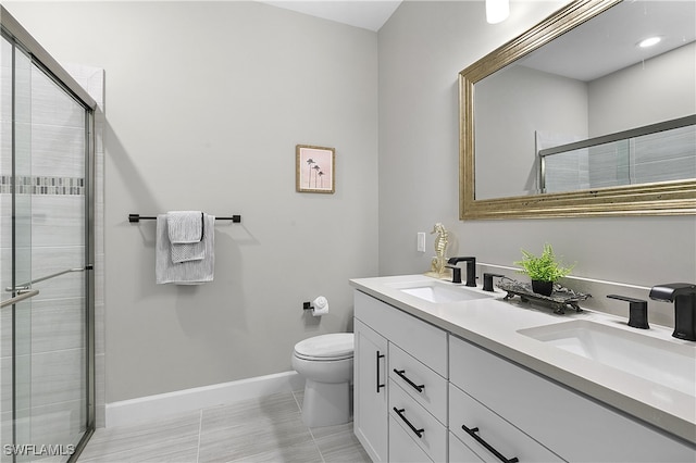 bathroom featuring tile patterned floors, vanity, toilet, and a shower with door