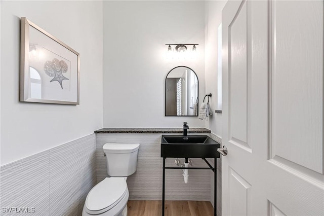 24800 Hollybrier Ln, Bonita Springs, FL 34134 - half bath featuring wainscoting, wood finished floors, and tile walls