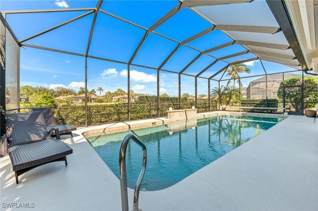 view of pool with a patio and glass enclosure