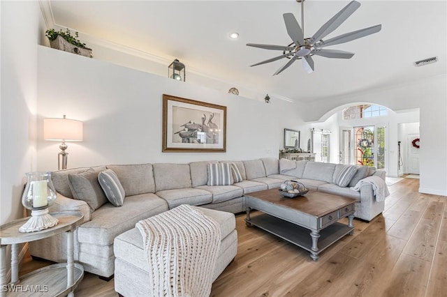 living room with ceiling fan, crown molding, and light wood-type flooring