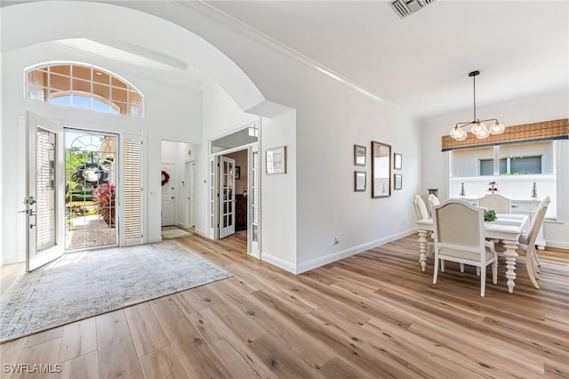 24800 Hollybrier Ln, Bonita Springs, FL 34134 - foyer entrance with light wood-style flooring, a chandelier, and arched walkways