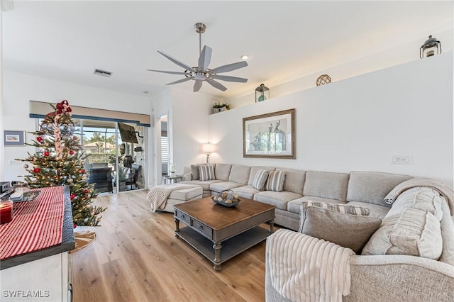 living room with light hardwood / wood-style flooring, ceiling fan, and ornamental molding