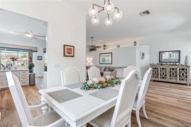 dining area featuring ceiling fan with notable chandelier, light wood-type flooring, and ornamental molding