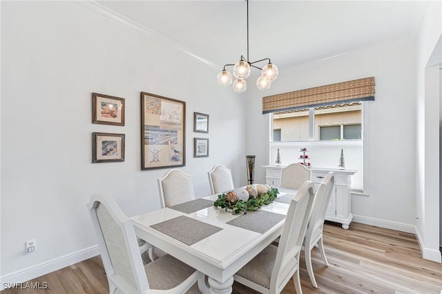 dining space with an inviting chandelier, light hardwood / wood-style flooring, and ornamental molding