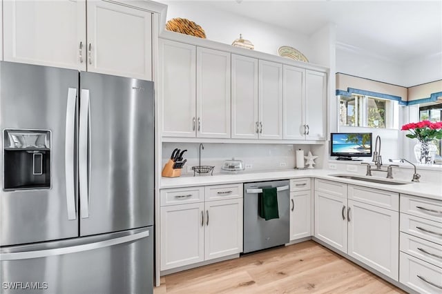 kitchen featuring white cabinets, appliances with stainless steel finishes, light hardwood / wood-style floors, and sink