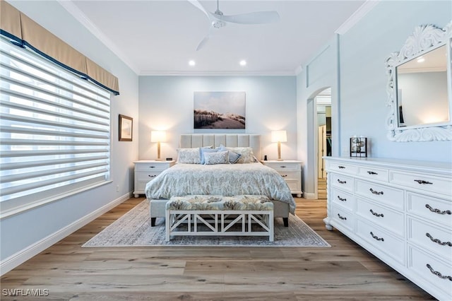 bedroom featuring light hardwood / wood-style flooring, ceiling fan, and ornamental molding